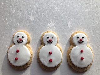 Gingerbread snowman cookies isolated on white with snowflakes and copy space