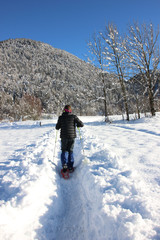 Snowshoe walker running in powder snow in Trentino, Italy. Outdoor winter activity in the Alps.