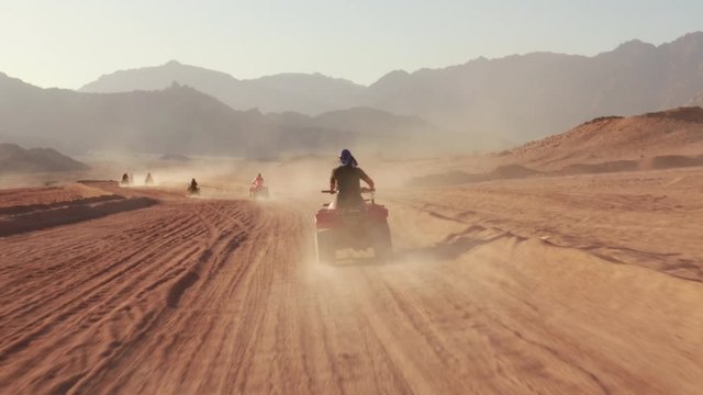 Quad bike ride through the desert near Sharm el Sheikh, Egypt.Adventures of desert off-road on ATV.Sand and Sand Borkhan. Rock and sunset. Quad Cycle Travel. Excursion with people.
