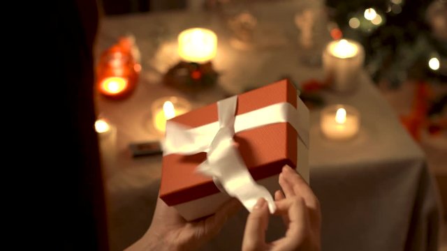 young girl opening a christmas present. new year atmosphere at home. close up hands