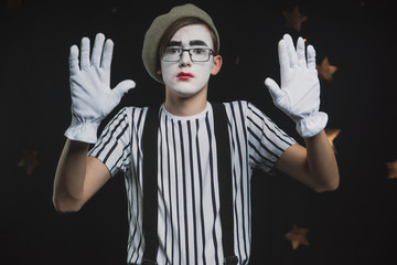 A MIME in a striped shirt in a circus tent shows a sketch