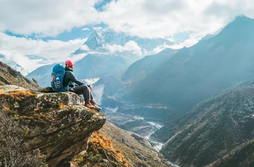 Photo sur Plexiglas Ama Dablam Jeune randonneuse randonneuse assise sur le bord de la falaise et profitant de la vue sur le pic d& 39 Ama Dablam à 6 812 m pendant l& 39 itinéraire de randonnée du camp de base de l& 39 Everest (EBC) près de Phortse, au Népal. Image de concept de vacance