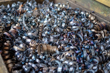 A lot of metal shavings lies in a container in a manufactory.