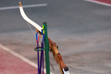Side view of a bow for shooting and arrows on the background of a sports field. Waiting for the...