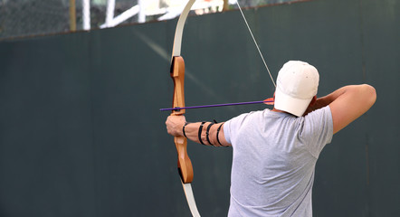 View from the back of a man during archery. Cropped shot, horizontal, close-up. Sport and hobby concept.
