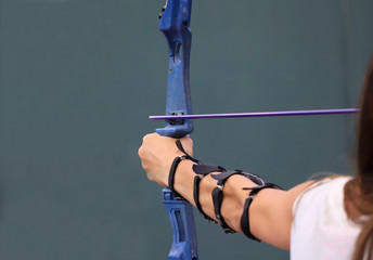 View from the back of a girl's hand during archery. Cropped shot, horizontal, close-up. Sport and hobby concept.