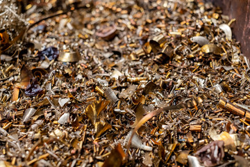 A lot of metal shavings lies in a container in a manufactory.