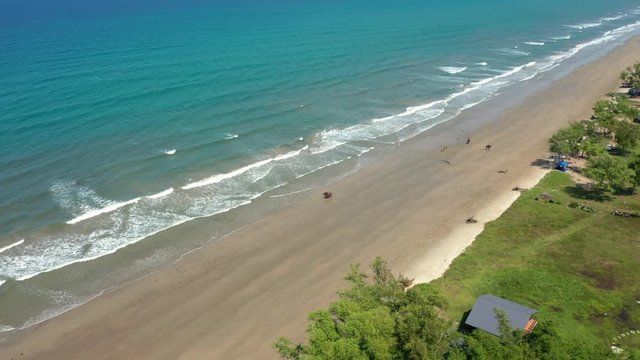 4K Aerial footage view of ocean waves crashing on Beautiful beach by at Sabandar Beach, Tuaran, Sabah, Malaysia