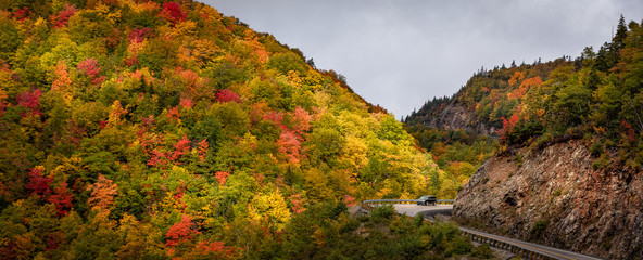 A lone vehicle negotiates the sharp bends of Cabot Trail in Cape Breton, Nova Scotia, Canada during...
