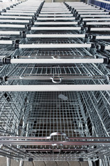 a long row of trolleys near the supermarket