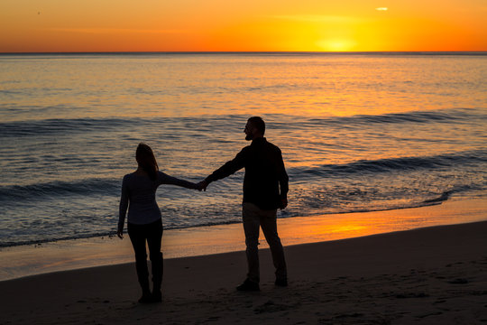 Couple in Love holding hands at Sunset in Malibu, Los Angeles