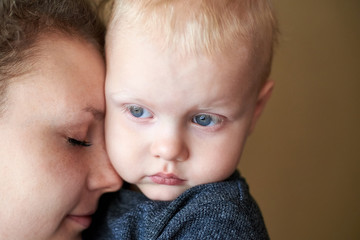 Mom gently snuggles up to her little son, close-up.