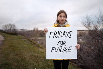 Teenager girl holding placard during global strike for climate change     