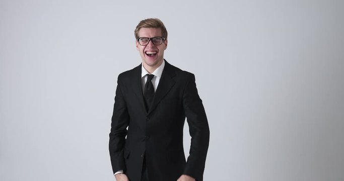 Excited businessman laughing and giving thumbs up gesture over white background
