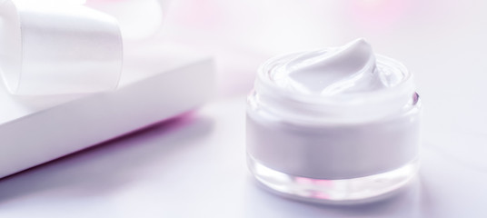 Facial cream moisturizer jar on holiday glitter background, moisturizing skin care as lifting...