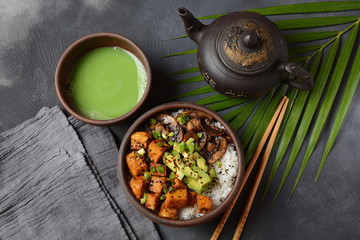 Sweet, spicy , crispy and fried Tofu in a bowl with terriayaki sauce, avocado,fried mushrooms, sesame seeds and rice. Served with green Matcha Tea. Healthy vegan food, gluten-free