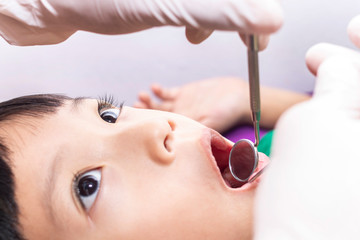 The dentist examining little boy teeth in dental clinic.