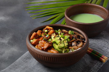 Sweet, spicy , crispy and fried Tofu in a bowl with terriayaki sauce, avocado,fried mushrooms, sesame seeds and rice. Served with green Matcha Tea. Healthy vegan food, gluten-free