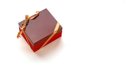 Red gift box wrapped with golden ribbon on Christmas ornaments. Isolated on white background and copy space. 