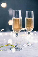 Champagne glasses on the table with a glowing garland
