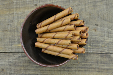 Chocolate waffle roll in black bowl, top view
