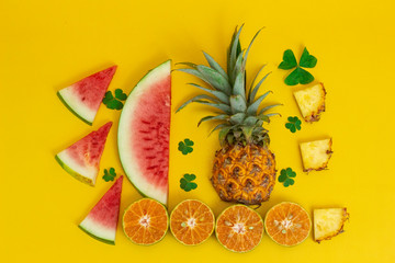 exotic tropical fruits, pineapple, orange, watermelon isolated on a yellow background
