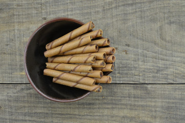Chocolate waffle roll in black bowl, top view