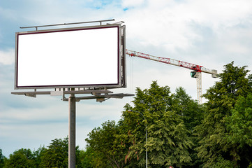 Blank white billboard mockup against trees and crane