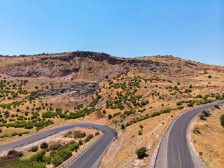 Aerial view of Kahta Sincik Road, close to Katha river near the village of Taslica, District of Kahta, Adiyaman Province, Turkey. Winding roads surrounded by nature with cars and vehicles