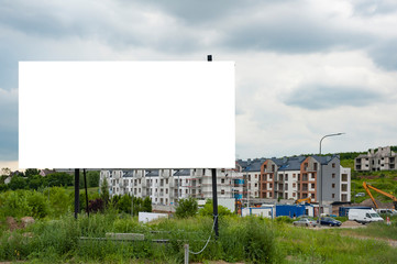 Obraz premium Blank white advertising billboard in the front of construction site on residential area