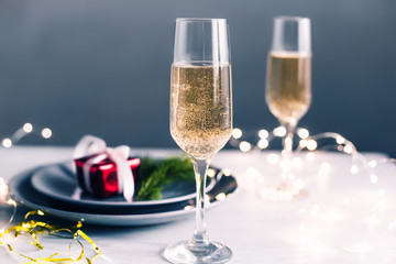 Christmas and new year table champagne glasses and plates with gifts