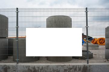 Blank white banner mockup on the fence of construction site