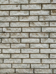 Rock stone wall background made of bricks on a wall of the building in the outdoors facade with rough texture and interesting natural material pattern