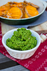 Green pesto paste dip in bowl.