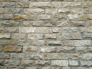 Modern rock stone wall background made of bricks on a wall of the building for the outdoors masonry with rough texture and interesting antique retro natural pattern
