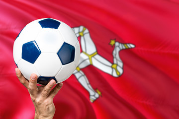 Isle Of Man soccer concept. National team player hand holding soccer ball with country flag...