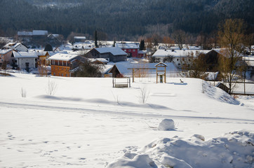 Dorf mit Kinderspielplatz im Winter
