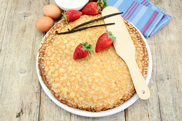 Breton crêpes and strawberries on a wooden table