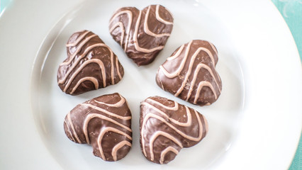Christmas gingerbread in the form of hearts on a white plate and a blue tablecloth