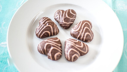 Christmas gingerbread in the form of hearts on a white plate and a blue tablecloth
