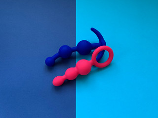 Blue and pink anal plugs. Two sex toys. Two colors  background. Useful for sex shop. 