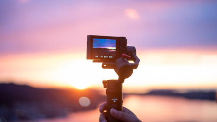 Camera on stabilizer is recording beautiful view at twilight - obrazy, fototapety, plakaty