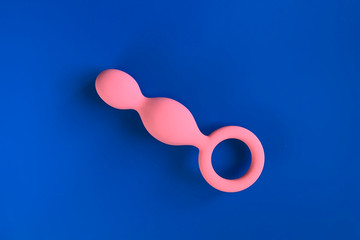 Pink anal plug for sex. On blue background. Flat Lay foto. Useful for sex shop or adults.