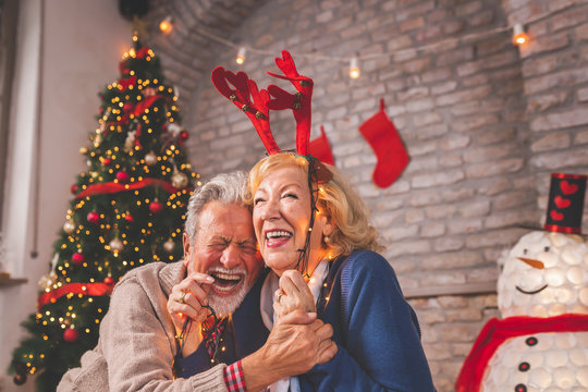 Senior couple having fun while decorating home for Christmas