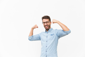 Happy joyful guy making hand winner gesture. Handsome young man in casual shirt and glasses...