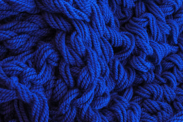 A Classic Blue knitted blanket background in a cozy style. Flat lay.
