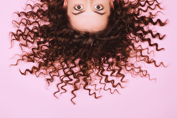 Big beautiful eyes of suprising young woman on pink background. Vertical photo, close up. - 307892661