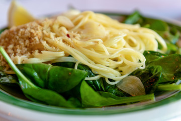 Italian cuisine pasta on spinach, close-up and selective focus