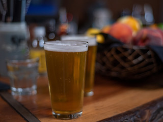 Two glasses of beer, selective focus, in a bar setting