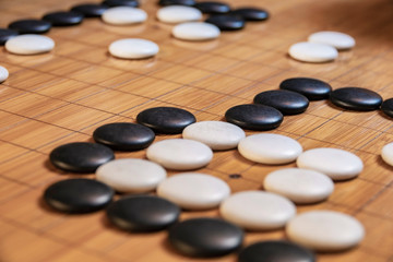 Go board game playing. A competitor is placing a marble piece on a Go board game